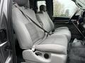 Interior view of a 2006 Ford F-450 SD showing two front seats with gray upholstery and seatbelts