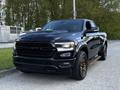 A black 2019 RAM 1500 pickup truck with a bold front grille and alloy wheels parked on a roadway