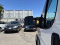 A 2016 RAM Promaster with a side mirror in focus parked among other vehicles in a lot