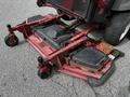 A red Toro Groundsmaster 2012 mowing deck with large black cutting blades and adjustable brackets on wheels for maneuverability