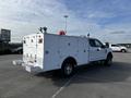 A white 2017 Ford F-350 SD truck with a utility body featuring multiple compartments and large rear lights