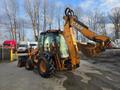 A 2015 Case 590SN backhoe loader with a yellow and black color scheme and an extended loader arm in the raised position with a bucket attachment