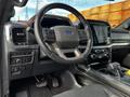 Interior of a 2021 Ford F-150 showing the steering wheel dashboard controls and center console with touchscreen display