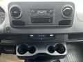 Interior dashboard of a 2021 Mercedes-Benz Sprinter featuring a central console with a radio display and dual cup holders