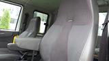 Interior view of a 2012 International 7400 featuring two gray fabric seats with armrests and a simple design