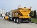 A 2016 International 7600 truck with a yellow cargo bed designed for transporting materials and equipped with specialized features for industrial use