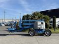 A blue 2012 Genie Z 45/25 articulated boom lift with a maintenance station and large wheels, designed for elevated work and access tasks