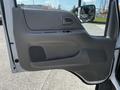 A gray door panel of a 2009 Ford LCF 550 featuring a handle a storage pocket and ventilation grilles