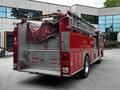 A red 1991 Sutphen Deluge fire truck with a ladder on top and a tarp covering the rear compartment featuring warning signs to keep back 500 feet