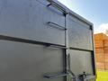 A 2016 Isuzu NPR truck with a dark-colored cargo area featuring horizontal handles and a lock chain on the side