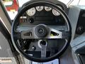 A 2006 Emergency One Fire Truck dashboard featuring a steering wheel, various gauges, control buttons, and a gear shift in a gray interior setting