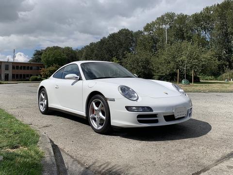 A white 2008 Porsche Carrera with a sleek design and sporty stance featuring alloy wheels and a prominent front grille