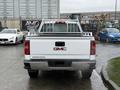A white 2015 GMC Sierra 1500 pickup truck viewed from the rear with a metal rack mounted in the truck bed