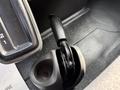 A close-up view of the gear shift lever and parking brake handle inside a 2014 International TerraStar vehicle
