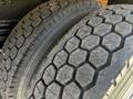 Close-up of two truck tires showing a deep tread pattern with hexagonal shapes and visible wear on the surface of the rubber