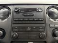 Dashboard of a 2011 Ford F-250 SD showing the sound system controls and climate settings with various dials and buttons