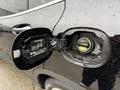 A 2016 Mercedes-Benz GLA-250 with its fuel door open revealing the gas cap and a QR code label inside the fuel compartment