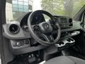 Interior view of a 2019 Mercedes-Benz Sprinter showing the steering wheel dashboard controls and center console with cup holders