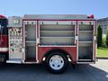 A red 1991 International 4600 fire truck with compartments for equipment and a control panel featuring various buttons and gauges