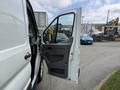 A 2017 Ford Transit van with the driver's side door open showcasing the interior features and controls