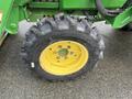 The image shows a close-up of a tire from a 2003 John Deere 790 tractor featuring a yellow rim and patterned black tire tread