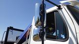 Close-up of a 2017 Freightliner M2 106 truck with a focus on the side mirror and part of the cab showing a chrome mirror and the window area