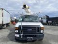 White 2008 Ford Econoline with a raised aerial lift on top visible in the foreground