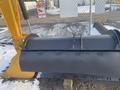 A 2000 plow with a 12-foot attachment designed for snow removal featuring a wide, flat blade and mounting brackets for attachment to equipment