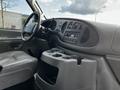 Interior view of a 2004 Ford Econoline showing the dashboard steering wheel and center console with cup holders and radio controls