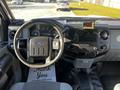 Interior view of a 2011 Ford F-350 SD showing the steering wheel dashboard controls and audio system with a thank you mat on the floor