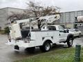 A 2012 Ford F-450 SD service truck with a Terex bucket lift attached and a white utility bed with storage compartments