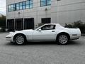 A white 1992 Chevrolet Corvette in profile view with a convertible top and distinctive rounded headlights