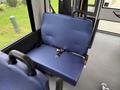 A blue bench seat with a seatbelt inside a vehicle
