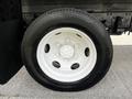Close-up of a white wheel with a five-bolt pattern mounted on a black tire, featuring visible tread and a metallic rim on a 2016 Isuzu NQR