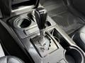 A close-up view of the gear shifter in a 2021 Toyota 4Runner featuring a black handle and an array of drive selection options