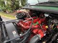 A 2015 Freightliner M2 106 engine with red and green components visible along with various hoses and electrical connections