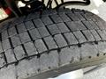 Close-up of a tire tread from a 2021 Ford F-550 showing deep grooves and wear patterns designed for traction and durability