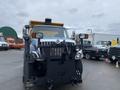 A blue 2016 International 7400 truck with a yellow plow attached at the front and a black snow removal blade mounted underneath