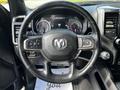 A black steering wheel with a RAM logo and various controls is in the foreground, showing the interior of a 2019 RAM 1500