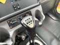 Close-up of a gear shifter from a 2016 Freightliner 108SD featuring a black handle with numerical pattern and control switches on the dashboard