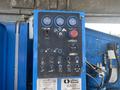 Control panel of a 1997 Genie S-65 4X4 featuring various gauges buttons and levers for operating the lift