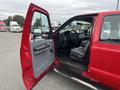 A red 2011 Ford F-250 SD with the driver's door open showcasing the interior layout and steering wheel