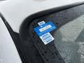 A 2014 Ford F-550 with raindrops on the window displaying a blue and white certificate of approval sticker