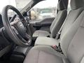 The interior of a 2017 Ford F-250 SD featuring two gray cloth seats and a steering wheel with controls