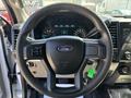 Steering wheel of a 2016 Ford F-150 featuring the Ford logo and control buttons for multimedia and driving functions