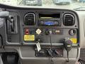 Dashboard of a 2014 Freightliner B2 featuring various controls, gauges, a radio, and warning labels