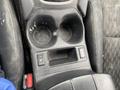 Cup holders and control panel of a 2019 Nissan Rogue showing two circular cup holders and a button panel