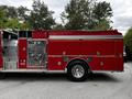 A 1991 Sutphen Deluge fire truck featuring a bright red exterior with multiple panels and equipment compartments on the side including valves and hoses