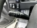 A close-up of the control lever in a 2018 Isuzu NPR featuring buttons for turn signals and cruise control settings