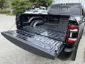 A 2024 RAM 2500 pickup truck with its tailgate open showing a spacious, empty truck bed